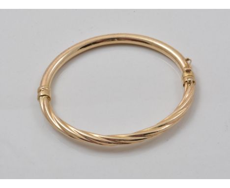 Yellow metal hinged bangle, half spiral, fluted.