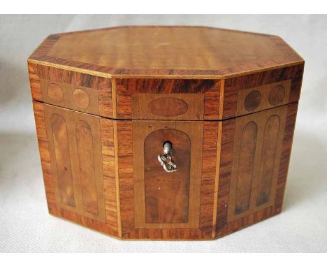 A Regency style multi wood inlaid Tea Caddy of elongated hexagonal form, the crossbanded hinged lid opens to reveal an inner 