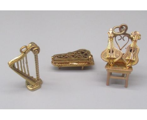 Three 9ct yellow gold charms including harp, chair with guitars and harpsichord, all stamped 375, gross 8.3g 
