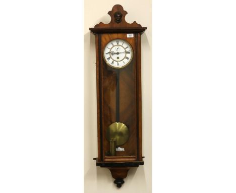 Late C19th walnut cased single weight Vienna wall clock shaped pediment with applied mask motif over fully glazed arch panel 