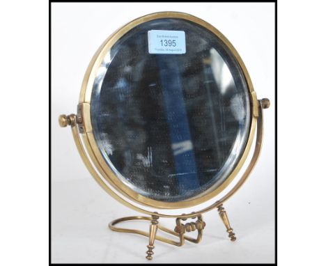 A 20th Century brass bevelled edge swing mirror of circular form raised on adjustable easel stand. Measures 23cm tall by 23cm
