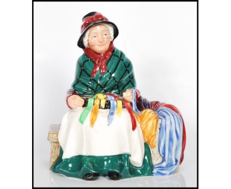 A Royal Doulton porcelain figure 'Silks and Ribbons ' no HN2017 depicting an old lady sat on a bench with a basket of ribbons