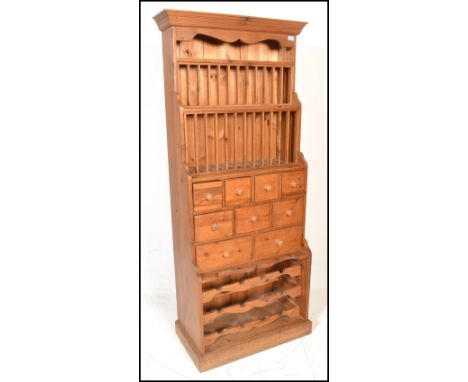 An antique style country pine upright plate rack / spice cabinet. Full size, freestanding cabinet raised on a plinth base wit