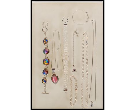 A collection of silver jewellery to include a child's christening bangle, a toggle bracelet set with glass panels, a four str