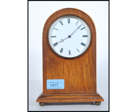 An Edwardian mahogany dome top mantel clock with enamel dial having roman numeral chapter ring and faceted hands. Measures: 2