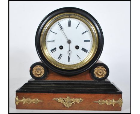 A 20th Century French style mantel clock on a plinth base with gilt scrolled detailing having a round case above with a white