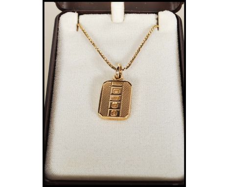 A 9ct gold box link necklace chain set with a gold hallmarked ingot pendant of oblong form having engine turned decoration. H