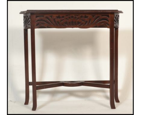 An early 20th Century 1910 Art Nouveau mahogany hall / console table having a pierced fretwork frieze. Raised on four flared 