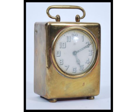 An early 20th Century brass / bronze cased desk travel carriage clock having a white enamel face with faceted hands. Raised o