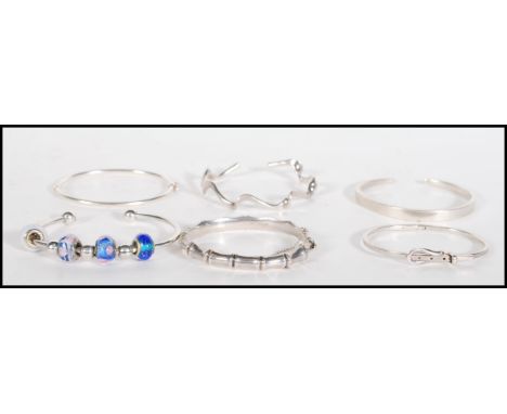 A selection of stamped 925 silver bangle bracelets ro include a a bamboo bangle with a hinge opening, a bangle threaded with 