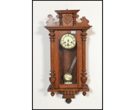 A 20th Century Vienna walnut cased regulator wall clock having a carved scallop shell pediment to the top,&nbsp; glazed panel