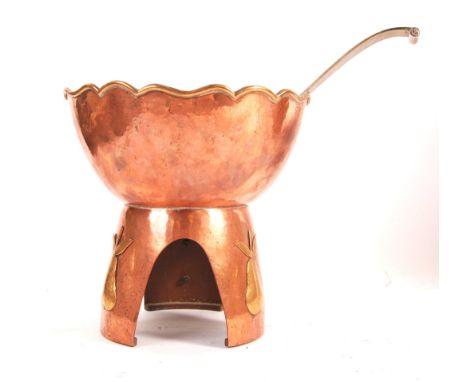 An arts and crafts period copper and brass punch bowl / table top pear poacher raised&nbsp;on a tripod arched base having han