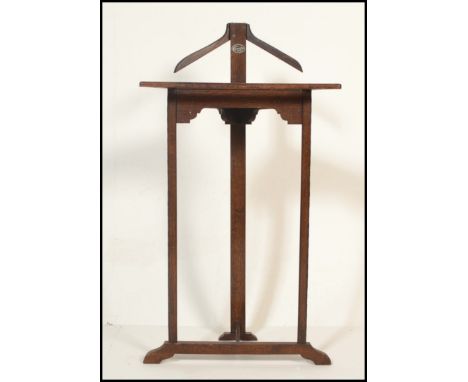A early 20th Century Edwardian oak valet butlers stand of triangular form having a piece of white milky glass inset forming a