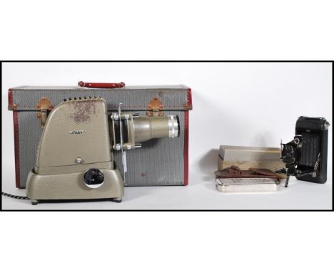 A vintage Aldis slide projector with original instructions, contained within original gray and red case. Together with a Roll