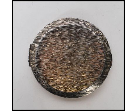 A vintage silver hallmarked Kigu compact of round form having a bark effect exterior and mirror to the inside. Hallmarked Lon