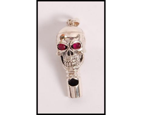 A stamped 925 silver whistle in the form of a skull set with ruby eyes. Weight 15.7g.&nbsp;