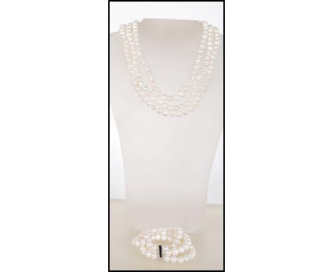 A 2 string cultured pearl necklace with barrel white metal clasp together with a matching 2 string pearl bracelet with white 