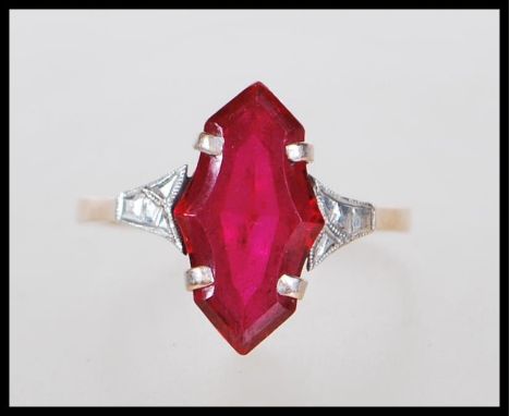 A 9ct gold ring having prong set synthetic fancy cut ruby with white gold shoulders on a lozenge shape set. Ring size P. Gros