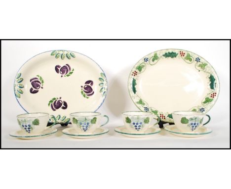 A small group of Poole Pottery ceramics in the Vineyard pattern to include four cups and saucers and a large meat platter. To