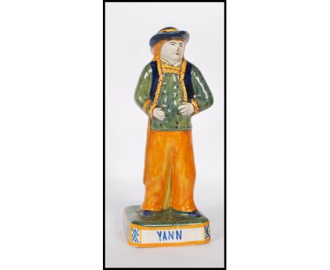 A 19th Century French Victorian ceramic faience figurine of a brightly glazed gentleman in hat with a long truncheon hanging 