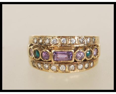 A 9ct gold suffragette style ring set with a row of purple and green stones flanked by two rows of white stones. Weight 5.3g.