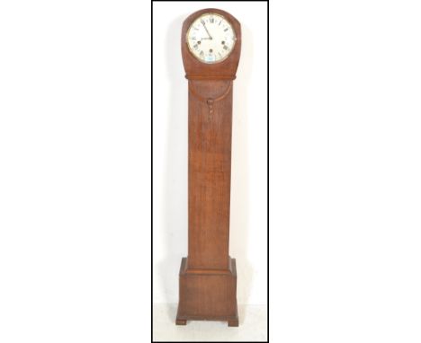 An early 20th Century Edwardian oak cased long case grandmother clock having a round white enamelled face with Roman Numerals