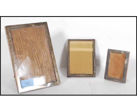 A group of three silver hallmarked easel back desk top picture frames, the largest with Birmingham assay marks and dating to 