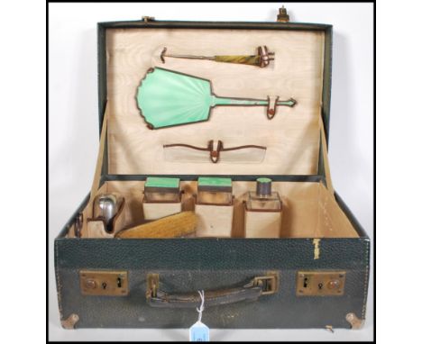 A 1930's silver and enamel hallmarked ladies vanity travel suitcase. The case to include glass vanity pots, mirror, brushes, 