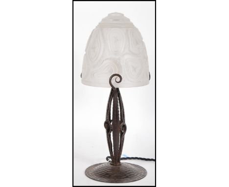 An early 20th Century Secessionist table lamp having hand worked metal base with frosted glass shade, raised in relief with s