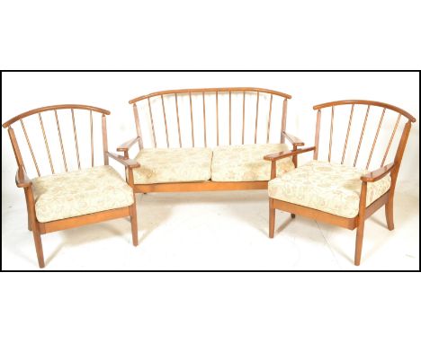 A vintage 20th Century open framed spindle back three piece suite in the manner of Ercol. consisting of a two seater sofa and