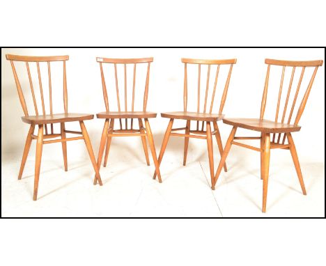 A set of four vintage retro 20th century Ercol beech and elm Windsor model 391 dining chairs having stick backs with shaped b