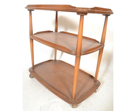 A vintage 20th century Ercol Golden Dawn 3 tier butlers serving buffet trolley. The elm tiers raised on beech tapering suppor