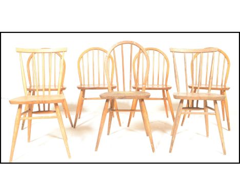 A harlequin set of mid century Ercol beech and elm wood dining chairs. Raised on turned legs united by stretchers having elm 