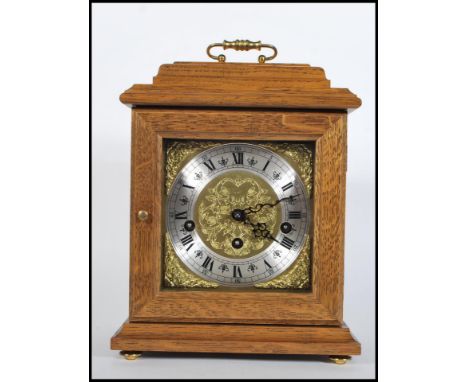 A 20th Century oak cased bracket clock, gilt engraved dial with silver chapter ring, Roman numerals, triple train driven move