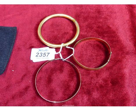 Two rolled gold bangles including one adjustable with engine turned detail plus a 9ct gold bangle (a/f).