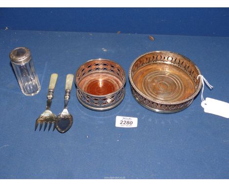 A silver plate on copper bottle coaster, 5" diameter, smaller 3 1/2" and a plated jam spoon and bread fork with Mother of pea
