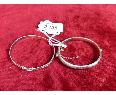 A Birmingham silver hinged bangle, date 1957 and a sterling silver adjustable floral bangle, 7.46 grams.