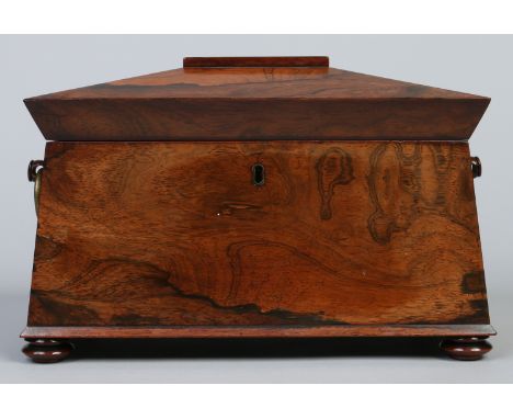A Regency rosewood tea caddy of sarcophagus form. With brass loop handles and raised on squat bun feet, 32.5cm wide.  Conditi