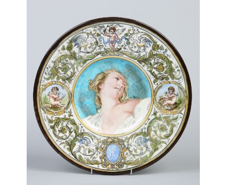A 19th century Leon Parvillee French faience enamelled dish painted by Berthe Rollot with the portrait of a woman under a wid