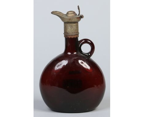 A 19th century brown glass bottle decanter with loop handle and white metal hinged cover with pouring spout, 22cm. Condition 