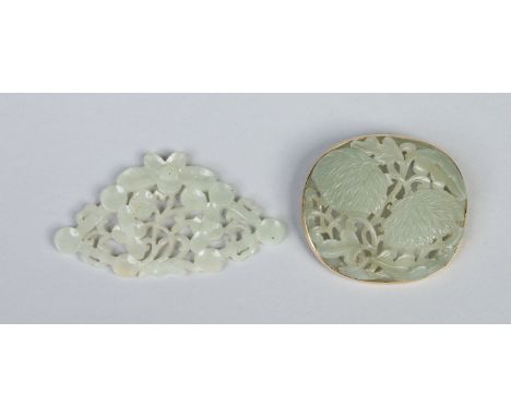 A Chinese pierced celadon jade ovoid brooch with yellow metal mount and a similar pierced pendant. Brooch 5.25cm wide.  Condi