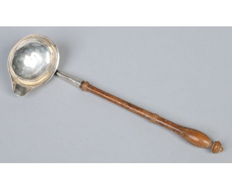 An early 19th century silver toddy ladle with turned fruitwood handle and single pouring spout, 30cm. Condition Report. To be