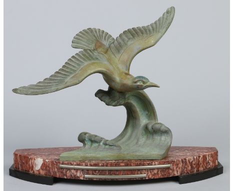 An Art Deco verdigris spelter figure of a seagull supported on a scrolling wave above a bow front marble and slate plinth, 47