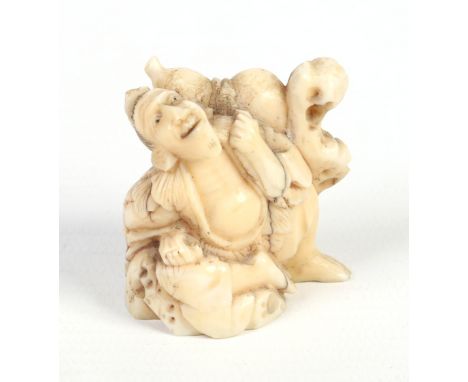 A Japanese Meiji period carved ivory netsuke formed as a travelling nomad leaning against a rock and with a double gourd flas