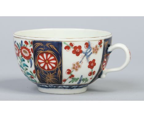 A Worcester tea cup with plain loop handle, painted with alternating scale blue panels and Japanese flowers, seal mark, c1765