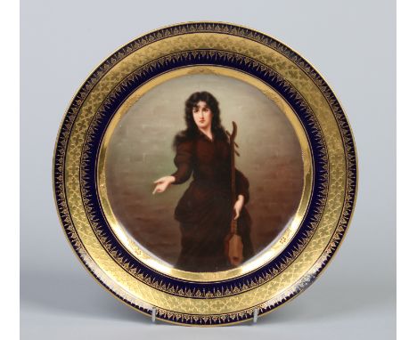 An early twentieth century Vienna plate with tooled gilt and cobalt blue border. Painted with the portrait of a woman with a 