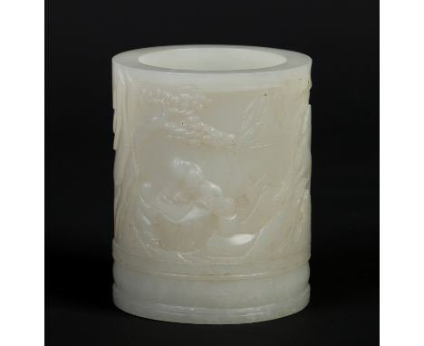 A Chinese carved celadon jade brush pot. Decorated in relief with figures playing chequers in a mountainous landscape, 9.5cm.