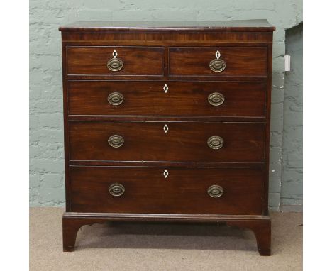 A George IV mahogany straight fronted two over three chest of drawers raised on bracket feet with cock beading and ivory escu