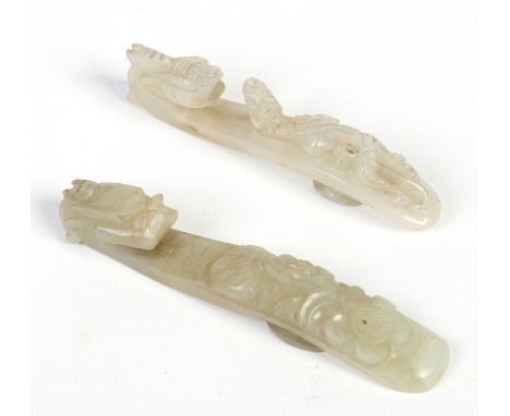 Two Chinese carved jade belt buckles, one celadon and one white. Largest 9cm.  Condition Report. To be used as a guide only. 