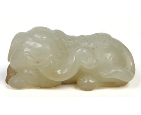 A 19th century Chinese carved celadon jade model of a recumbent elephant with slight coloured suffusions to the underside, 6c
